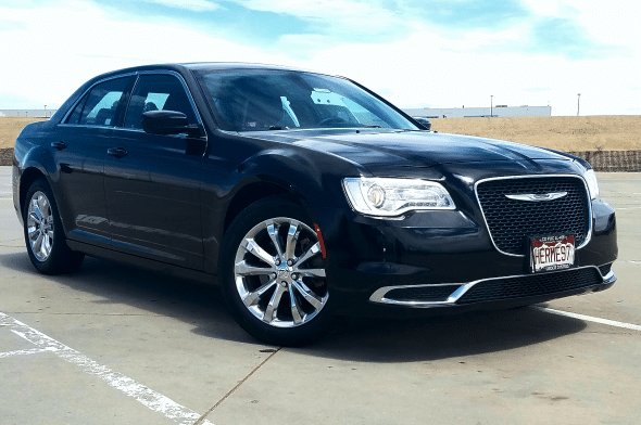 A black sedan with chrome wheels parked on a lot.