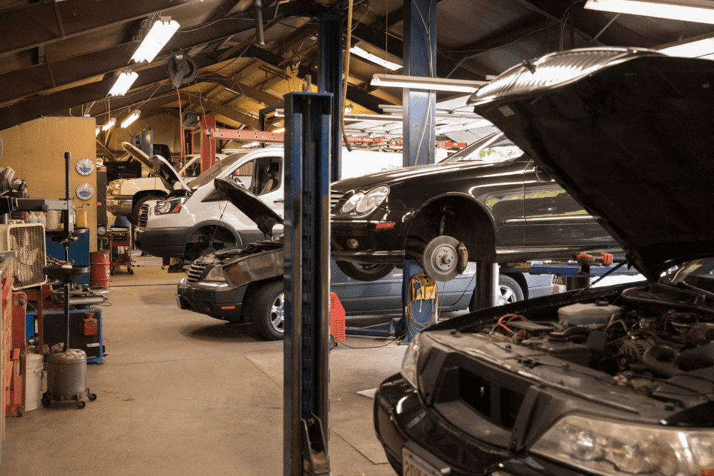 car tune-up, auto repair in Chicopee, MA at E & G Automotive. Busy auto repair shop with multiple vehicles on lifts and open hoods.