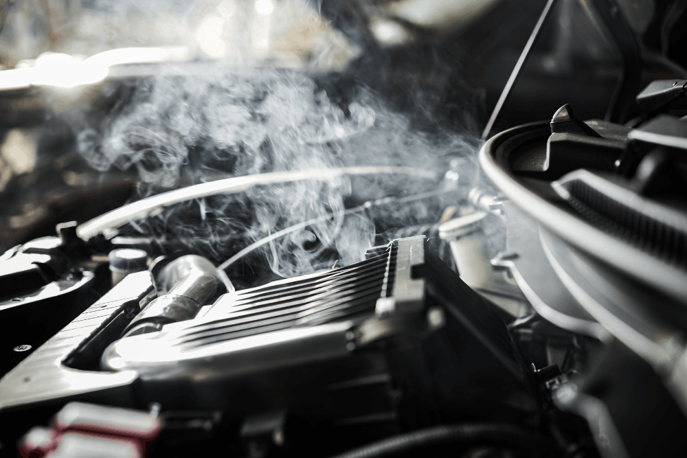 Engine overheating, auto repair in Chicopee, MA, at E&G Automotive. An image of steam rising from an overheating vehicle engine, illustrating engine overheating caused by cooling system failure, coolant leaks, or radiator problems requiring professional repair.