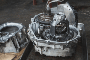 Transmission repair vs. replacement, auto repair in Chicopee, MA at E&G Automotive. Image of an opened transmission housing with visible differential gears, bearings, and internal components during automotive service.