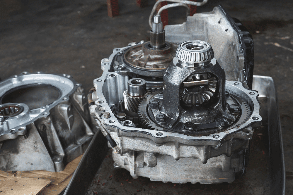 Transmission repair vs. replacement, auto repair in Chicopee, MA at E&G Automotive. Image of an opened transmission housing with visible differential gears, bearings, and internal components during automotive service.